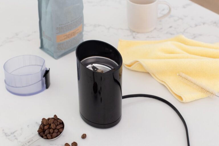 Home A clean coffee grinder on a wooden counter ready for a maintenance routine.