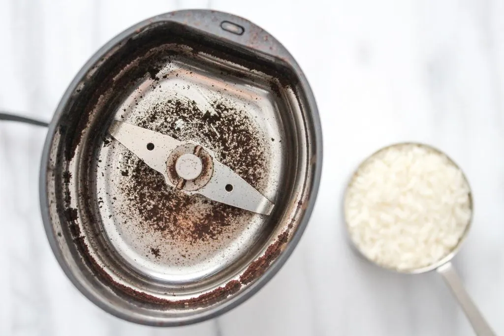 How to Clean Coffee Grinder With Rice in 15 Minutes Essential tools including white rice and a brush for cleaning a coffee grinder.